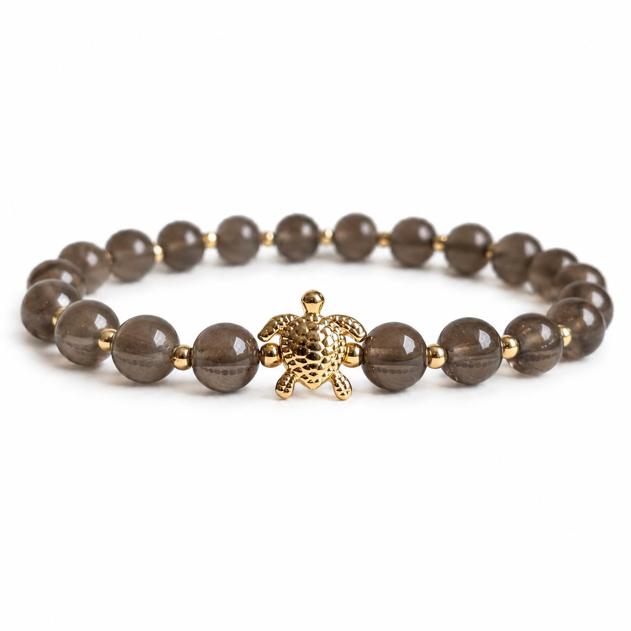 Bracelet with smoky quartz stone beads and a gold turtle charm on a white background