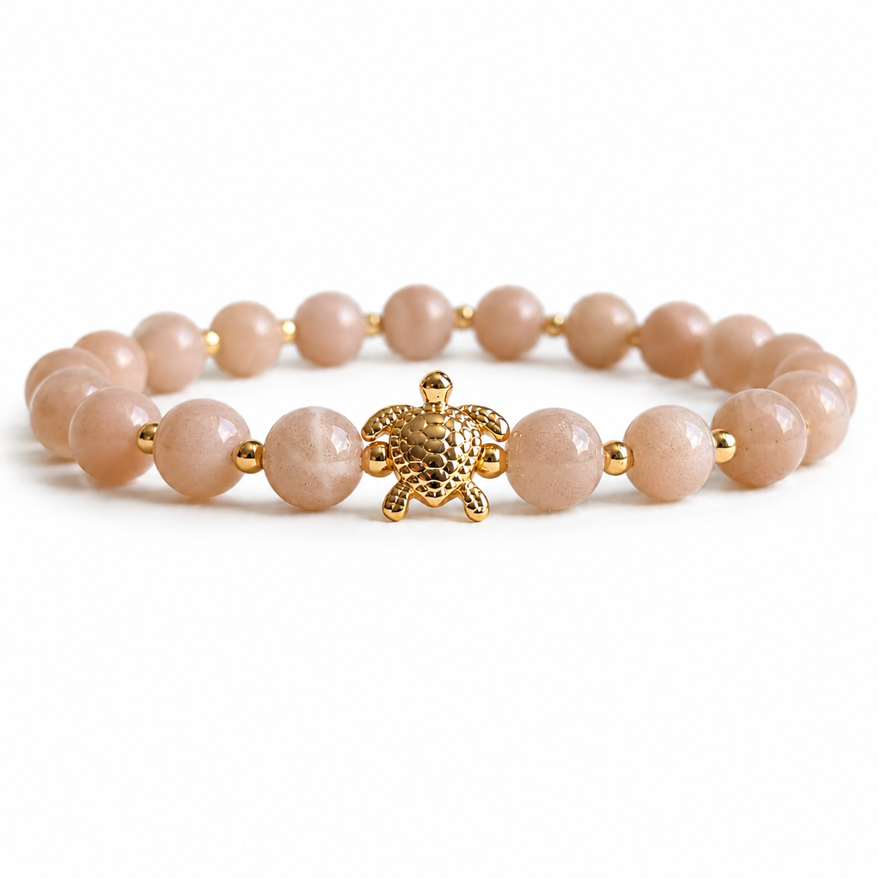 Bracelet with coral peach beads and a gold turtle charm on a white background