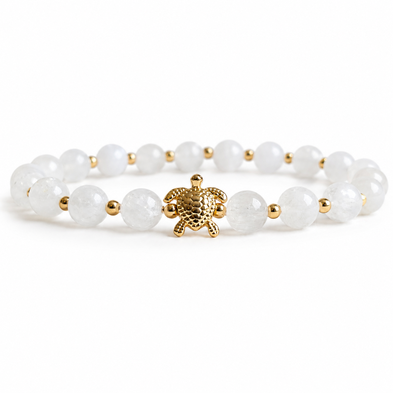 White beaded bracelet with a gold turtle charm on a white background